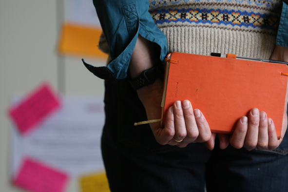 Woman holding a notebook, seen from the back